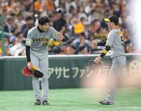 　４回、坂本の打球を好捕した近本（右）を最敬礼で迎える才木（撮影・西岡正）