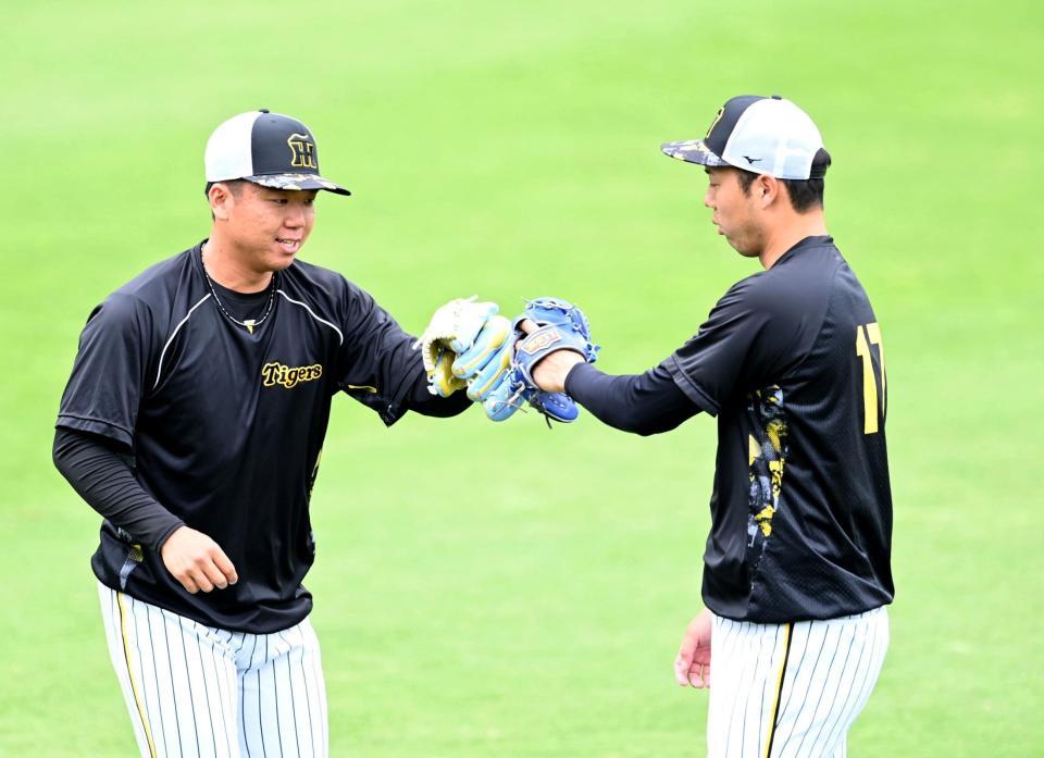 　キャッチボールを終え、青柳（右）とタッチを交わす村上（撮影・飯室逸平）