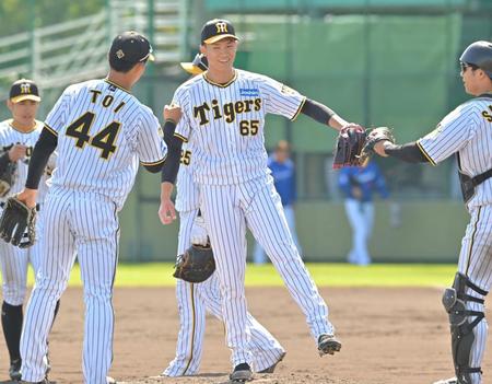 　９回、最後を締めた湯浅（中央）はナインと勝利のタッチを交わす（撮影・北村雅宏）