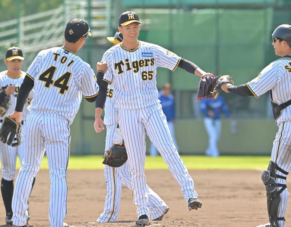 　９回、最後を締めた湯浅（中央）はナインと勝利のタッチを交わす（撮影・北村雅宏）