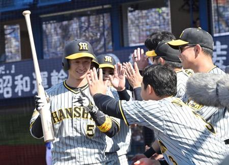 　３回、満塁本塁打を放ちナインの祝福に笑顔を見せる近本（５）＝撮影・立川洋一郎