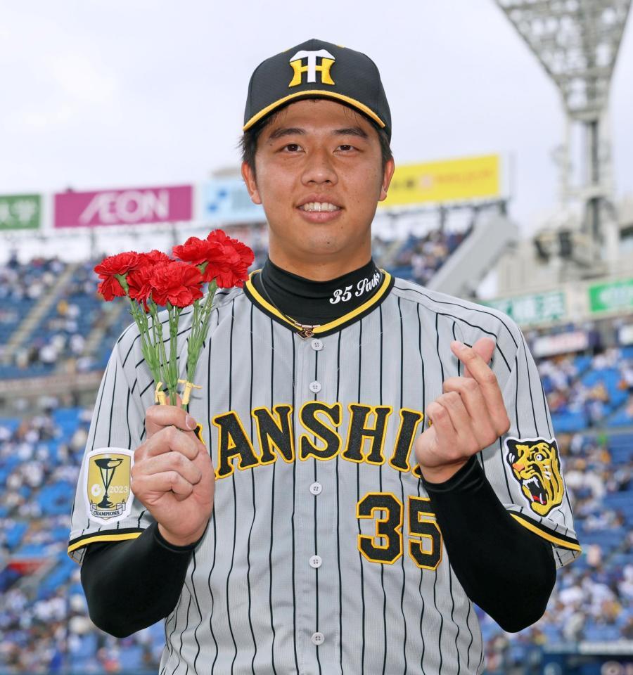 　完封勝利を飾りカーネーションを手に笑顔を見せる才木＝１２日
