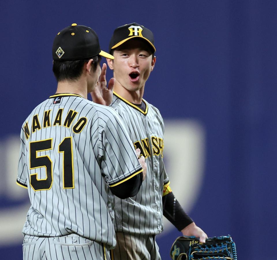 　適時打を放った近本は中野と勝利のタッチを交わす（撮影・田中太一）