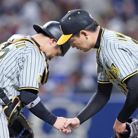 　勝利を決め、握手を交わす坂本（左）と岩崎（撮影・立川洋一郎）