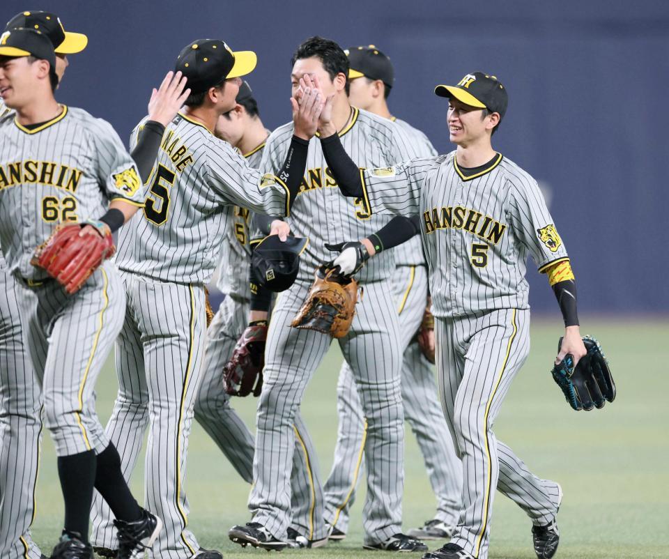 　ナインと勝利のタッチを交わす近本