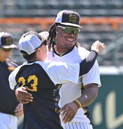 　練習中、糸原と抱擁を交わすミエセス（右）＝撮影・北村雅宏