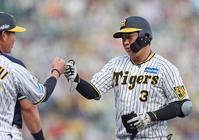 ２回阪神無死、左前打を放ち、阪神・筒井壮外野守備走塁コーチ（左）とタッチを交わす阪神・大山悠輔＝甲子園（撮影・中田匡峻）