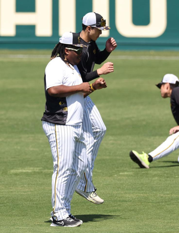 　１軍に合流し、小幡（右）から手荒い祝福を受けるミエセス（撮影・中田匡峻）