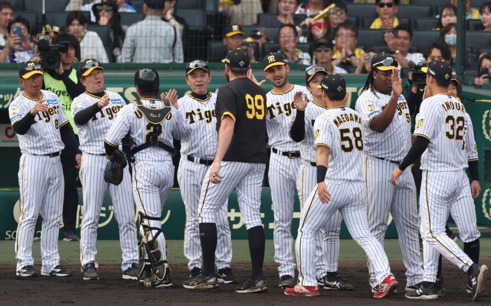 　ヤクルトに勝利し、ビーズリー（９９）らを迎える岡田監督（撮影・中田匡峻）