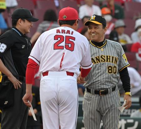 　メンバー表交換時に新井監督と握手する岡田監督（撮影・市尻達拡）