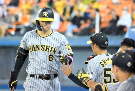 　７回、右越えソロを放ち、ベンチに迎えられる佐藤輝（撮影・伊藤笙子）