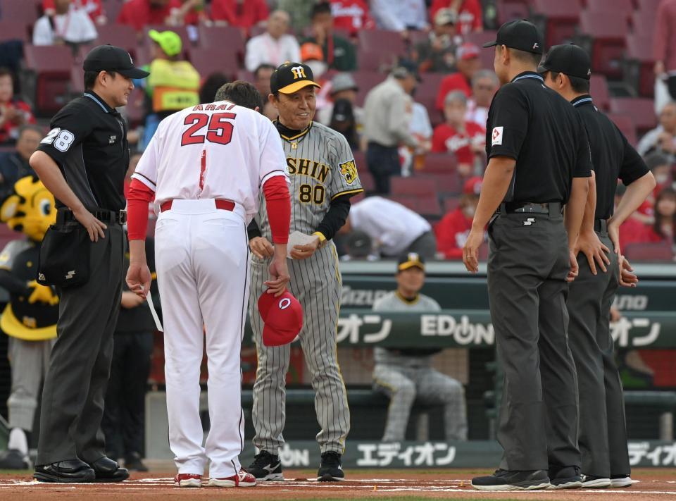 　メンバー表交換時に新井監督からあいさつを受ける岡田監督（撮影・市尻達拡）