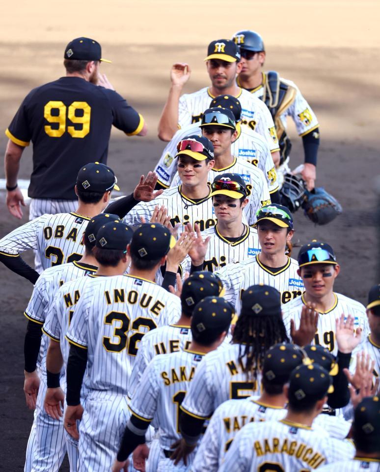 　巨人に勝利しタッチする木浪（中央上）ら阪神ナイン（撮影・山口登）