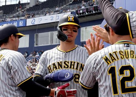 　６回、井上の３ランで生還しナインに迎えられる佐藤輝（撮影・金田祐二）