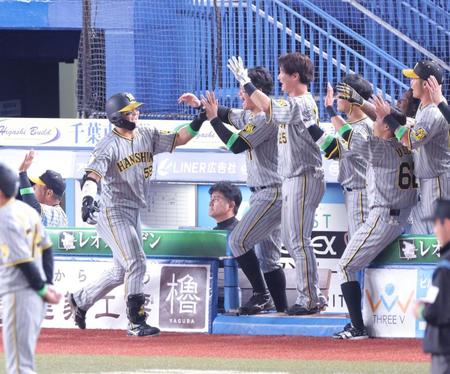 　６回、同点２ランを放ち、ナインとタッチを交わす前川（左）＝撮影・西岡正