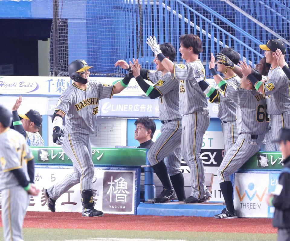 　６回、同点２ランを放ち、ナインとタッチを交わす前川（左）＝撮影・西岡正