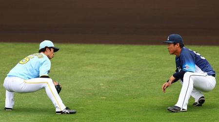 　試合前、グラウンドでアップする近本（左）は西武・陽川と談笑する（撮影・山口登）