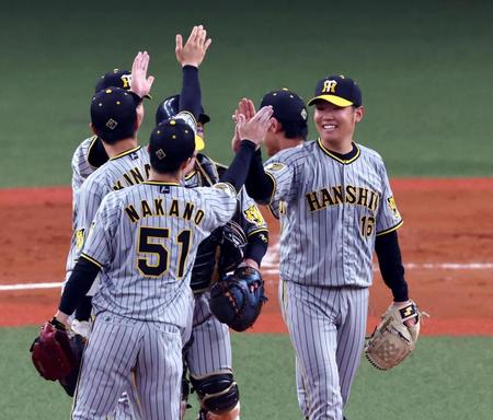 　西勇（右）は完封勝利を飾り笑顔でナインとタッチする（撮影・山口登）