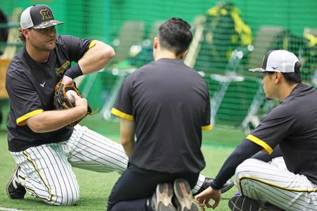 　佐藤輝（右）にグラブさばきのアドバイスをするノイジー（撮影・立川洋一郎）