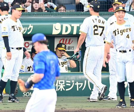 　４回、先制を許し、ベンチで厳しい表情の岡田監督（中央）＝撮影・飯室逸平