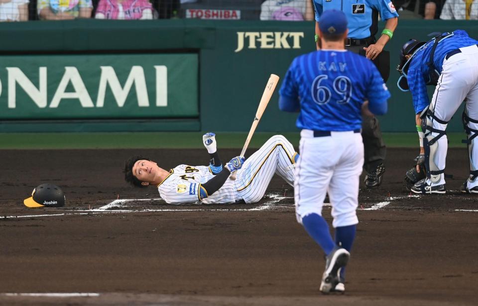 　１回、頭部付近の投球をよけ、倒れ込む近本（撮影・飯室逸平）