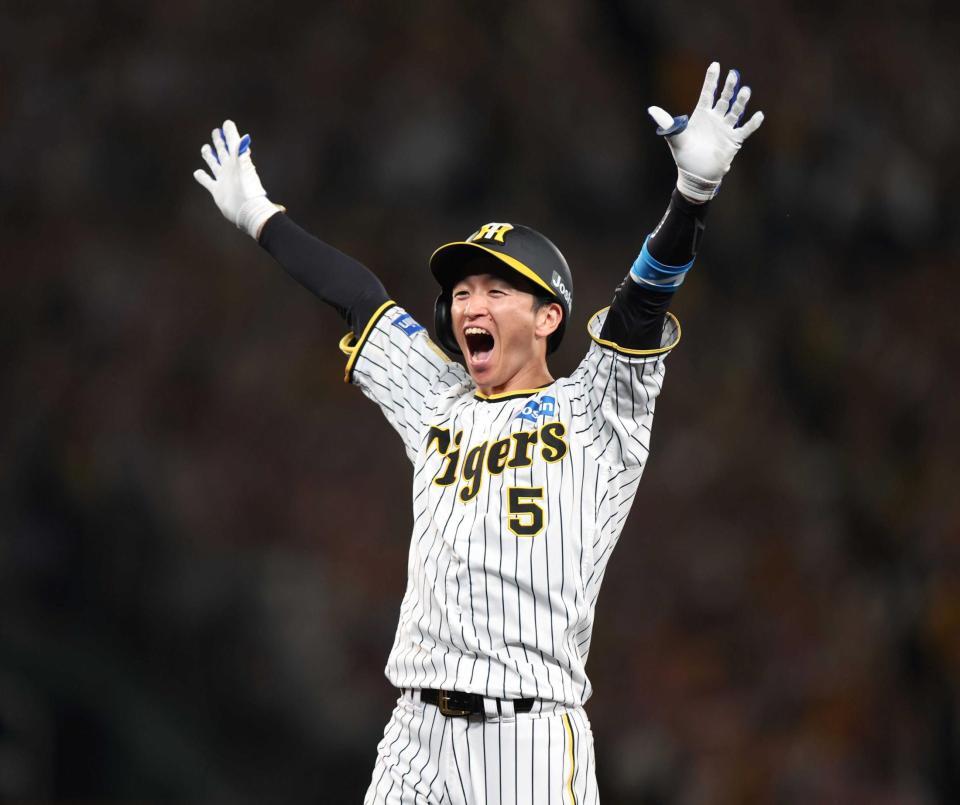 　９回、逆転２点適時打を放った近本は笑顔で万歳（撮影・中田匡峻）