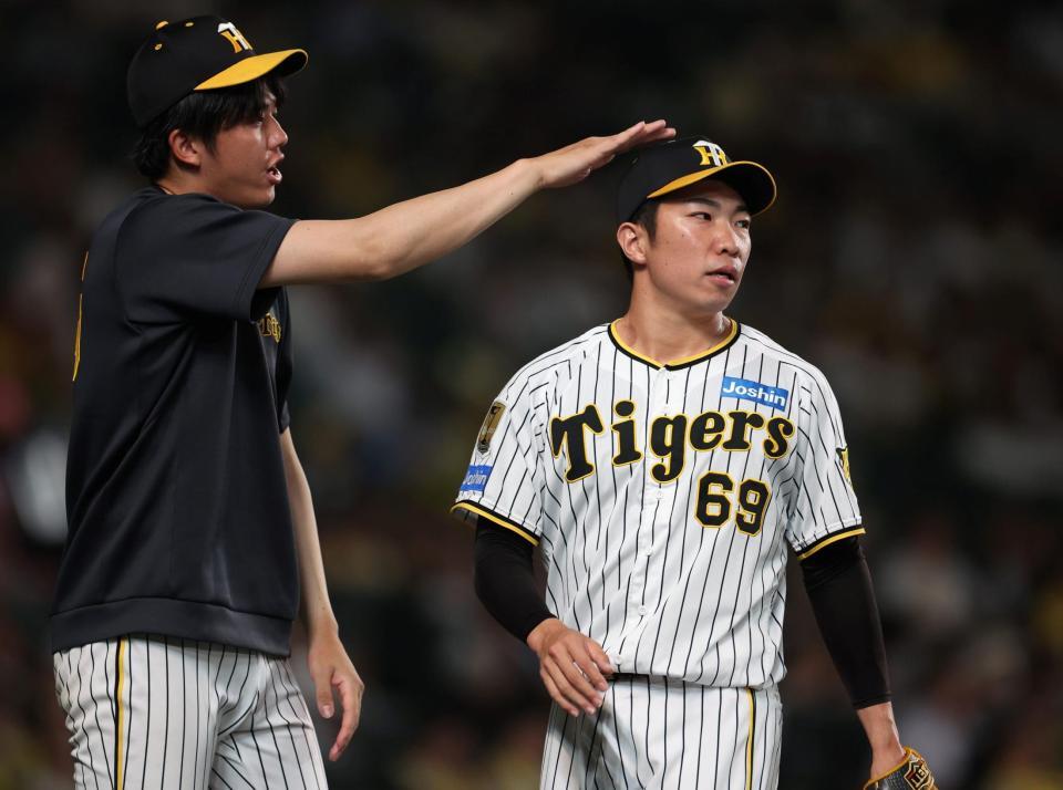 　９回を投げ終えた石井（右）は才木から出迎えを受ける（撮影・中田匡峻）