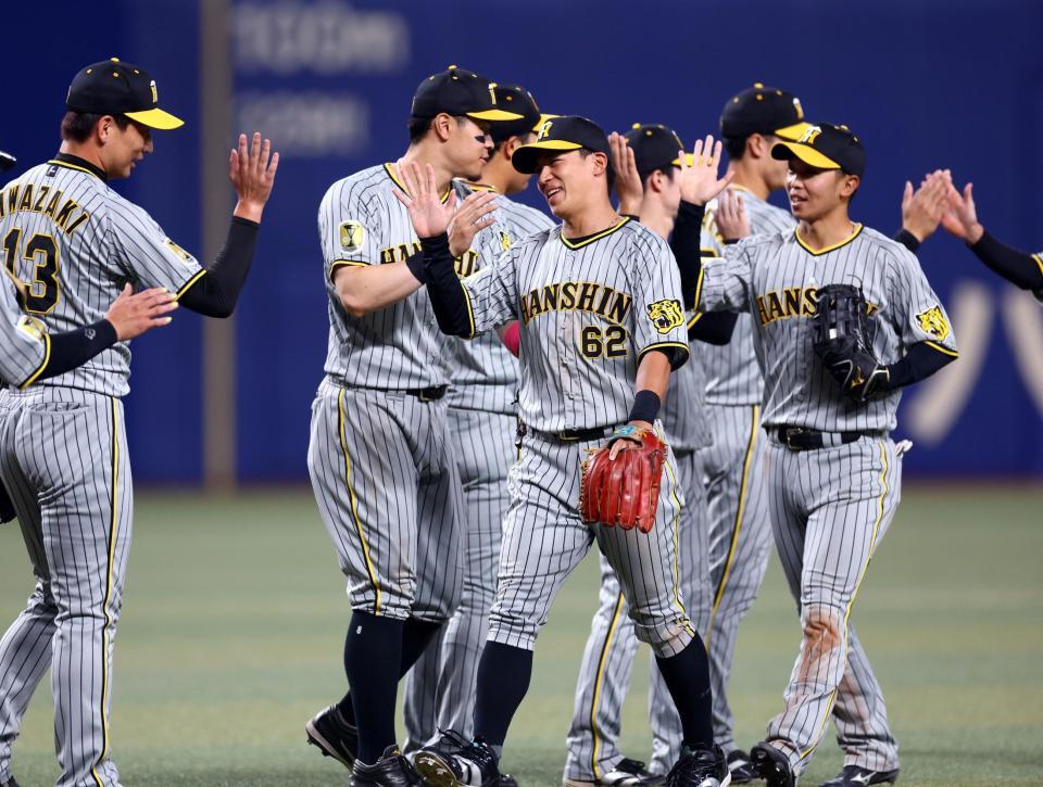 　中日に勝利しナインと笑顔でタッチする植田（中央）＝撮影・山口登