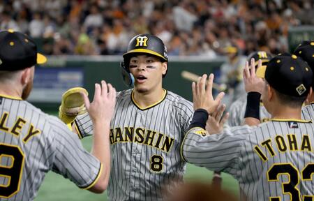 　４回、大山の適時打で生還した佐藤輝はナインとタッチを交わす（撮影・田中太一）