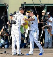 　横田さん（左）の引退試合で花束を贈る梅野＝２０１９年９月