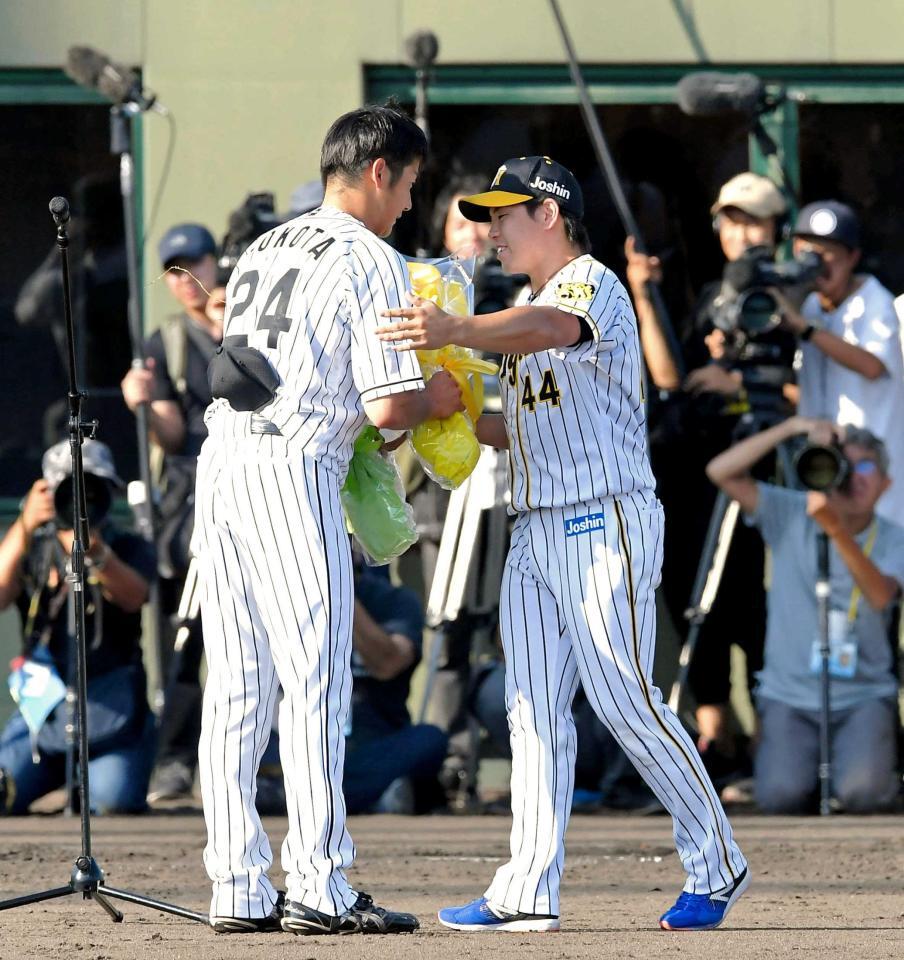 　横田さん（左）の引退試合で花束を贈る梅野＝２０１９年９月