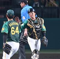 　勝利のタッチを交わす梅野（右）＝撮影・飯室逸平