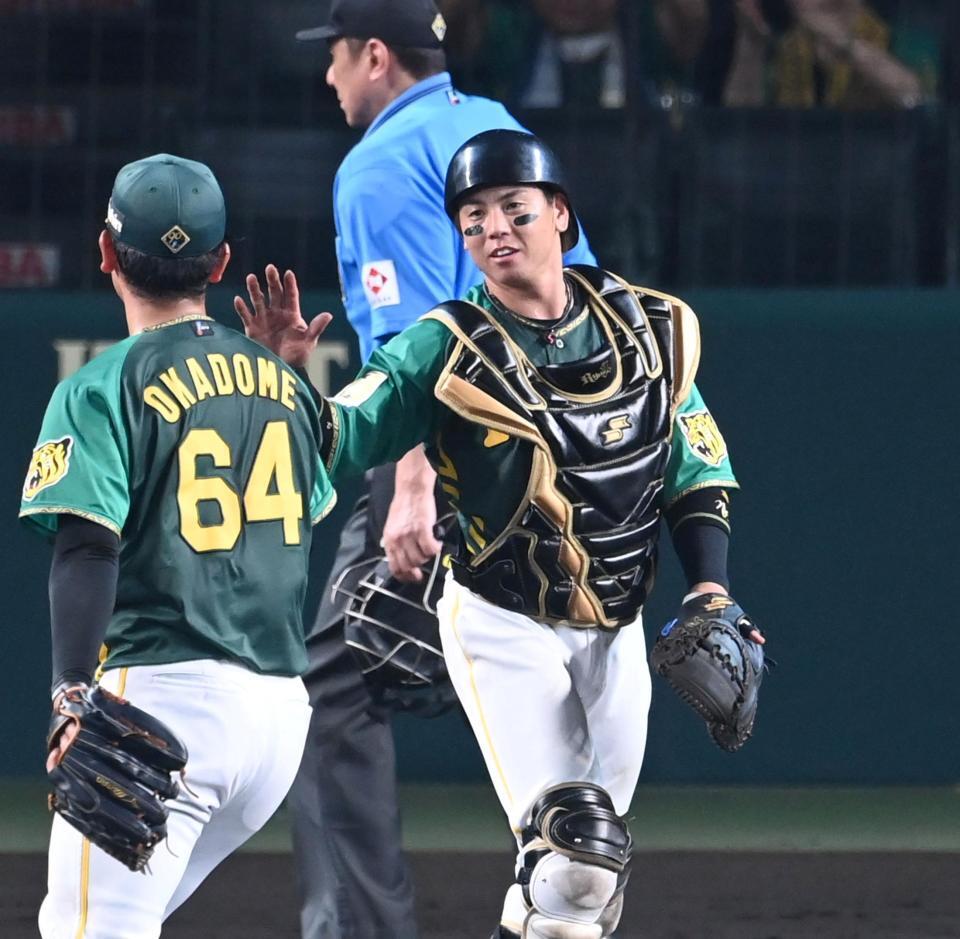 　勝利のタッチを交わす梅野（右）＝撮影・飯室逸平