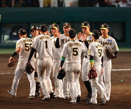 　１００周年の記念日に勝利し、笑顔でタッチする佐藤輝（右から３人目）ら阪神ナイン（撮影・山口登）