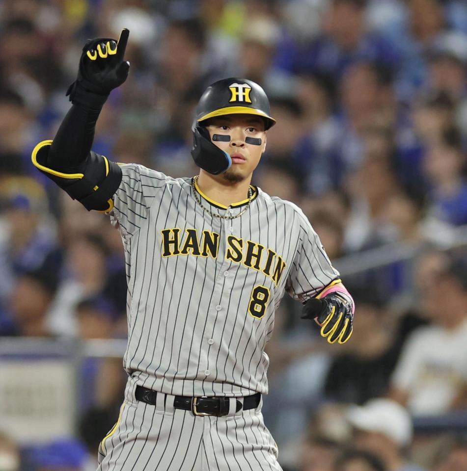 　５回、勝ち越し適時打を放ち、右手をあげる佐藤輝（撮影・田中太一）