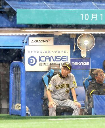 　５回、試合が中断し、激しい雨が降る中、グラウンドを見つめる岡田監督