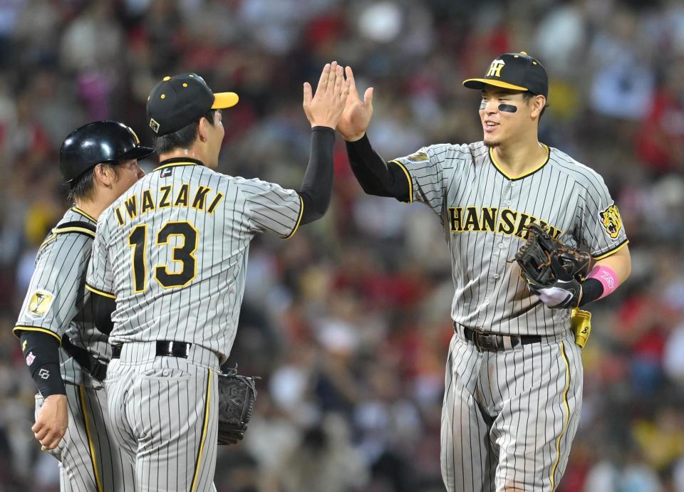 　勝利に貢献し、笑顔でタッチをする佐藤輝（撮影・市尻達拡）