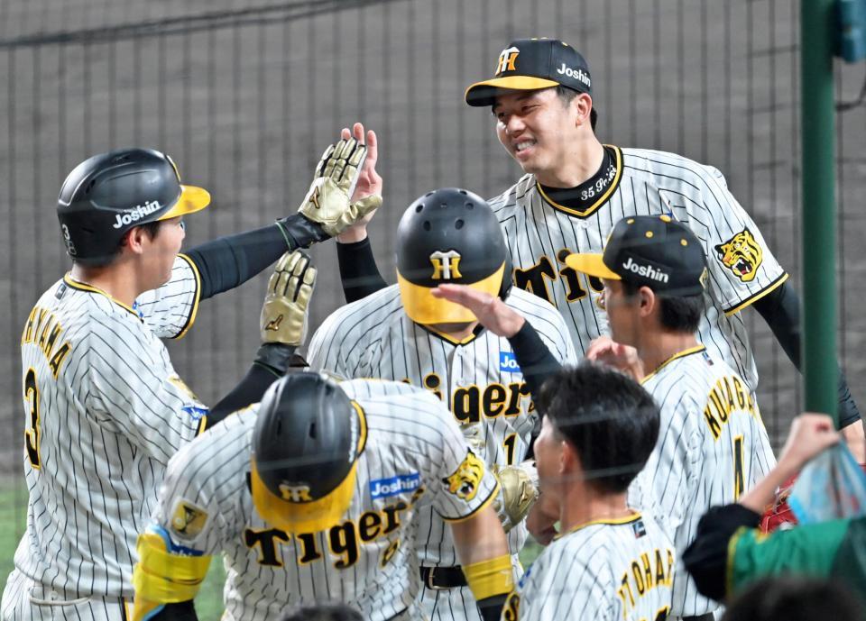 　６回、佐藤輝の逆転３ランで生還した大山（左端）とタッチを交わす才木（撮影・立川洋一郎）