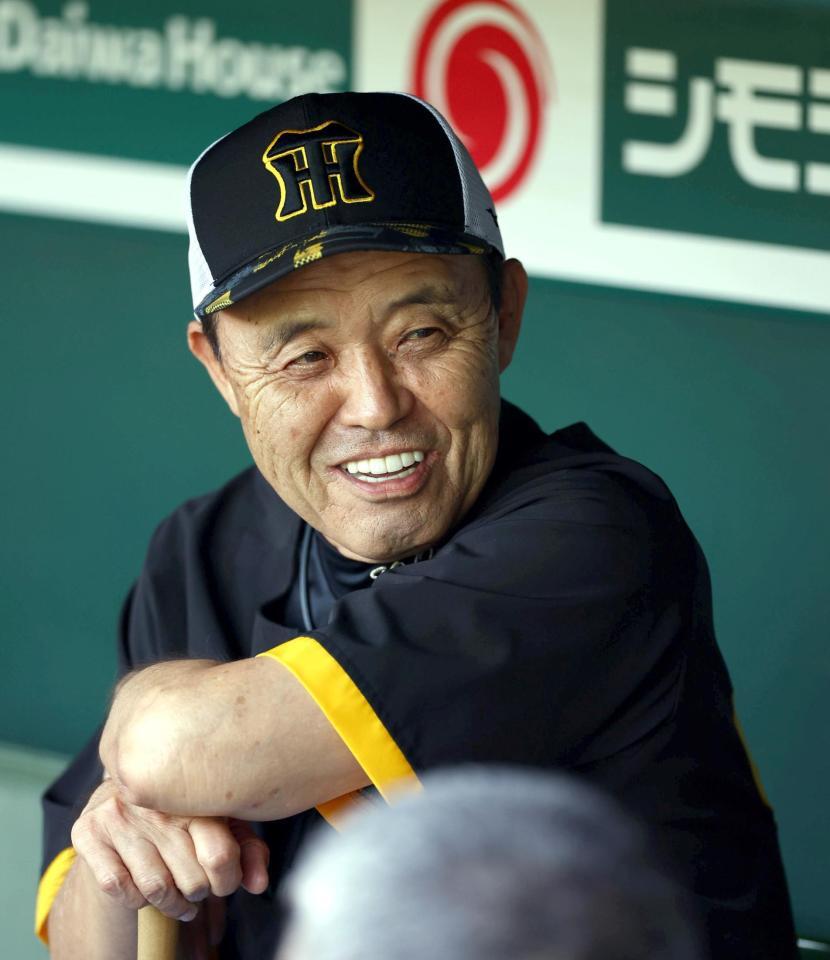 　練習中、ベンチで笑顔を見せる岡田監督（撮影・山口登）