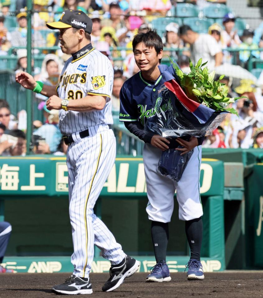 　岡田監督（左）から花束を手渡され笑顔を見せる青木（撮影・立川洋一郎）