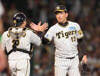 　最後を締めた岩崎（右）は梅野とタッチを交わす（撮影・中田匡峻）