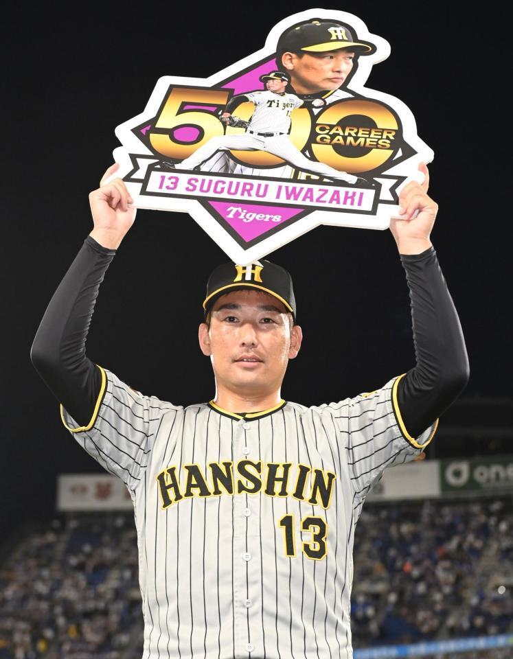 　プロ通算５００登板を達成した岩崎はボードを掲げる（撮影・田中太一）