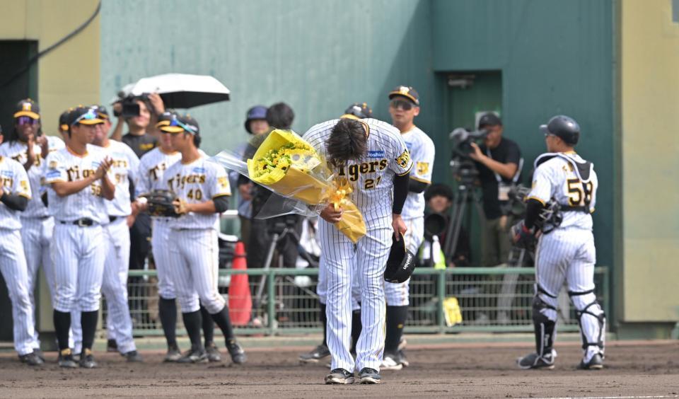 　１回を投げ終え、花束を受け取った秋山（中央）は深々と頭を下げる（撮影・北村雅宏）