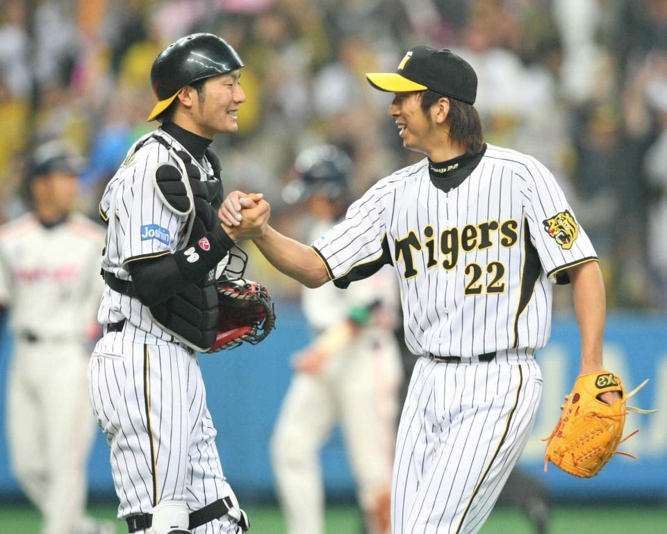 　開幕戦で勝利し、握手を交わす藤川（右）と狩野＝２００９年４月３日