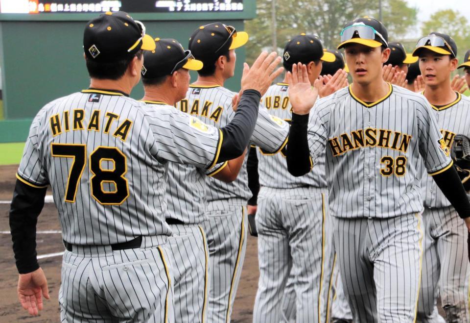 　勝利のハイタッチで山田（右）ら選手を迎える平田２軍監督（左）