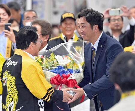 　高知入りし歓迎の花束を手渡されて笑顔を見せる藤川監督（右）＝撮影・立川洋一郎