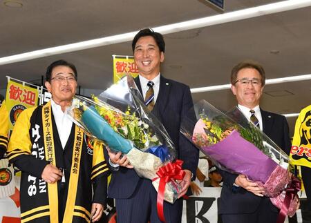 　横山幾夫安芸市長（左）から花束を受け取り、笑顔を見せる藤川監督。右は粟井一夫社長（撮影・中田匡峻）