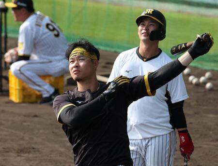 　右打ちでロングティーを行う佐藤輝。奥は野口（撮影・中田匡峻）