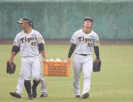 　突然雨が強まり、井坪（左）とボールを運びながら上空を見上げる前川（撮影・中田匡峻）