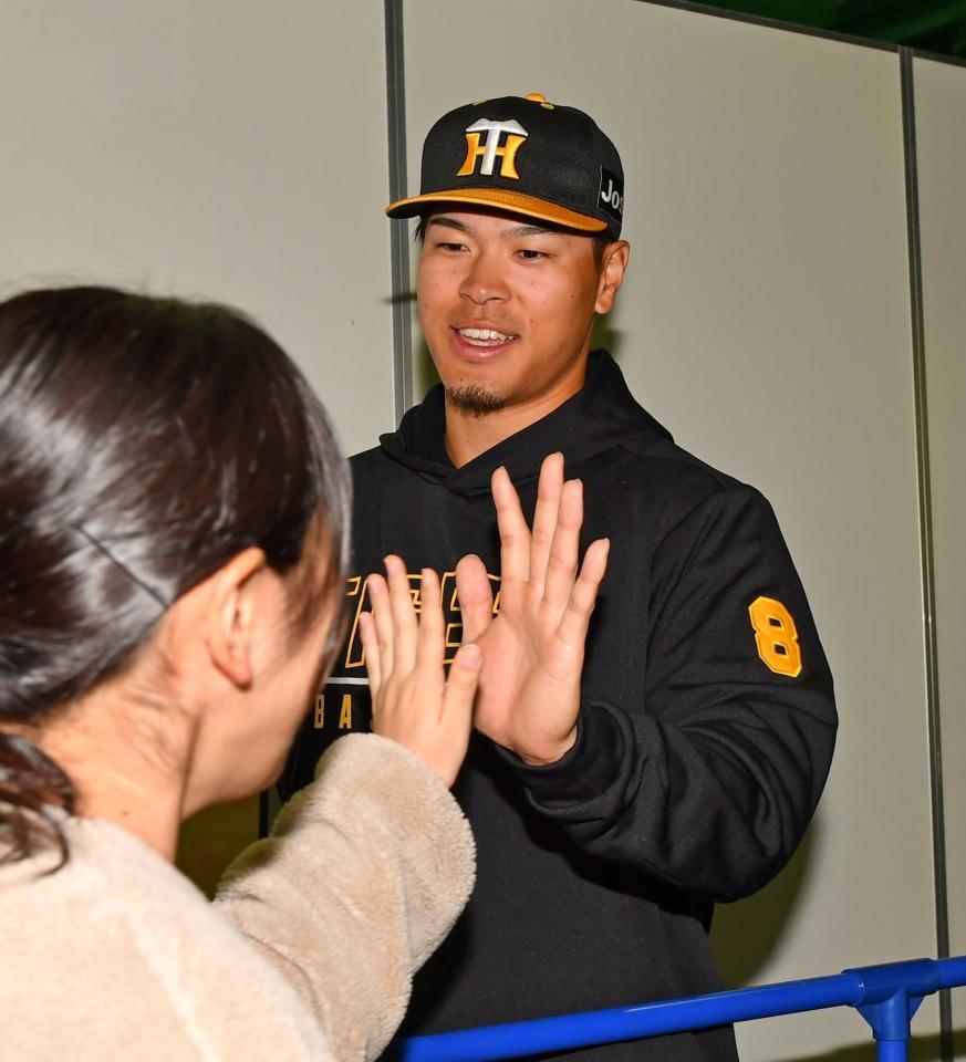 ファンとハイタッチを交わす佐藤輝（撮影・中田匡峻）